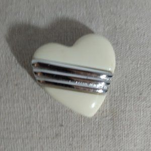 Heart shaped cream and silver tone brooch.